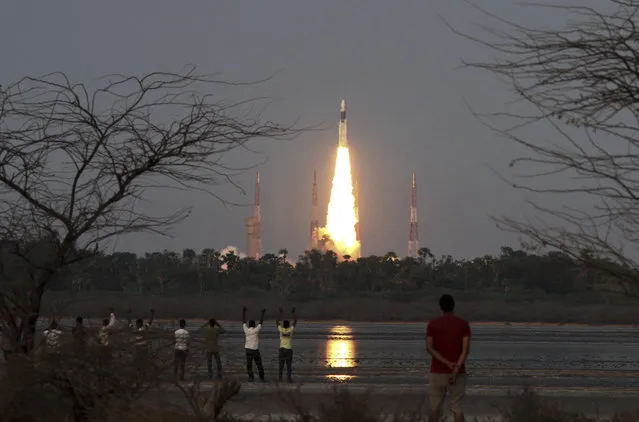 People watch as Indian Space Research Organization’s Geosynchronous Satellite Launch Vehicle Mk III rocket lifts off from the space launch center in Sriharikota, India, Monday, June 5, 2017. India’s space agency on Monday successfully launched its heaviest rocket carrying a communication satellite from the launch pad off the country’s southeastern coast. (Photo by AP Photo)