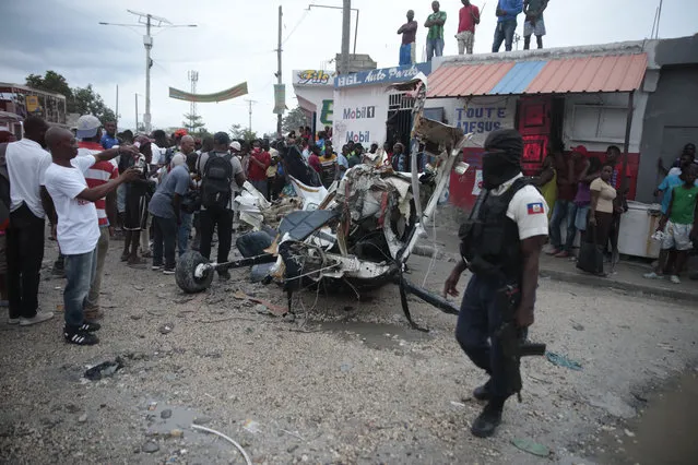 Police guard the crash site of a small plane in the community of Carrefour, Port-au-Prince, Haiti, Wednesday, April 20, 2022. (Photo by Joseph Odelyn/AP Photo)