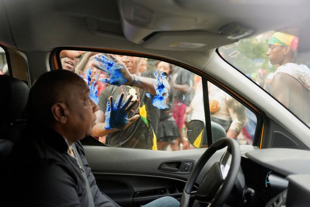 A man sits in a vehicle as revelers take part in the J'ouvert on the day of the annual West Indian American Day parade in the Brooklyn borough of New York City on September 2, 2024. (Photo by Cheney Orr/Reuters)