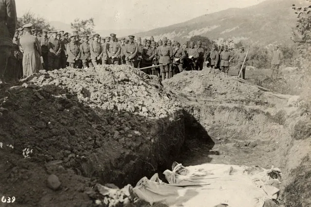 Austro-Hungarian soldiers stand in front of a mass grave on the Eastern Front in this 1915 handout picture. This picture is part of a previously unpublished set of World War One (WWI) images from a private collection. The pictures offer an unusual view of varied and contrasting aspects of the conflict, from high tech artillery to mobile pigeon lofts, and from officers partying in their headquarters to the grim reality of life and death in the trenches. The year 2014 marks the centenary of the start of the war. (Photo by Reuters/Archive of Modern Conflict London)