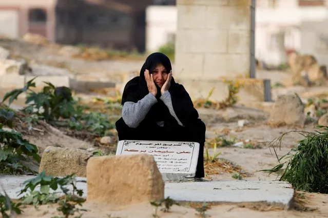 A Palestinian woman cries as she visits the grave of a relative at a cemetery, on the first day of Eid al-Fitr that marks the end of the holy fasting month of Ramadan, in Khan Younis, in the southern Gaza Strip on May 2, 2022. (Photo by Ibraheem Abu Mustafa/Reuters)