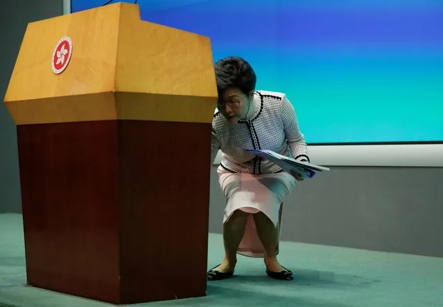 Hong Kong Chief Executive Carrie Lam leans to take her notes as she leaves after a news conference following her policy address for 2019, in Hong Kong, October 16, 2019. (Photo by Umit Bektas/Reuters)