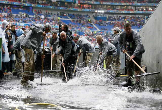 Workers clear water away prior to the UEFA EURO 2016 group E preliminary round match between Belgium and Italy at Stade de Lyon in Lyon, France, 13 June 2016. (Photo by Sergey Dolzhenko/EPA)