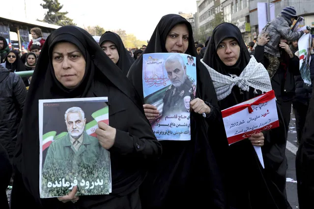 Mourners holding posters of Iranian Gen. Qassem Soleimani attend a funeral ceremony for him and his comrades, who were killed in Iraq in a U.S. drone strike on Friday, at the Enqelab-e-Eslami (Islamic Revolution) Square in Tehran, Iran, Monday, January 6, 2020. The processions mark the first time Iran honored a single man with a multi-city ceremony. Not even Ayatollah Ruhollah Khomeini, who founded the Islamic Republic, received such a processional with his death in 1989. Soleimani on Monday will lie in state at Tehran's famed Musalla mosque as the revolutionary leader did before him. (Photo by Ebrahim Noroozi/AP Photo)