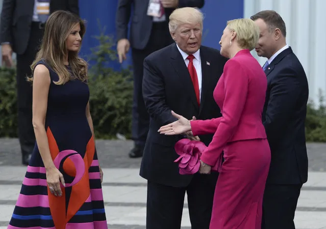 Poland's first lady Agata Kornhauser-Duda, second right, reaches her hand to U.S. First Lady Melania Trump as U.S. President Donald Trump reaches his hand for a handshake after his speech in Krasinski Square, with Polish President Andrzej Duda standing right, in Warsaw, Poland, Thursday, July 6, 2017. (Photo by Alik Keplicz/AP Photo)