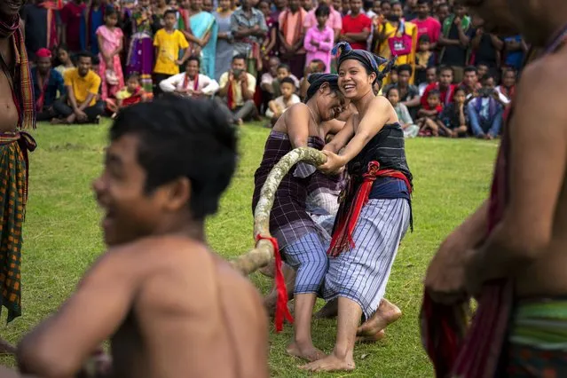 Indian Rabha tribal women in traditional attire take part in a tug of war competition with men during Baikho festival at Gamerimura village along the Assam Meghalaya border, west of Gauhati, India, Saturday, June 4, 2022. (Photo by Anupam Nath/AP Photo)