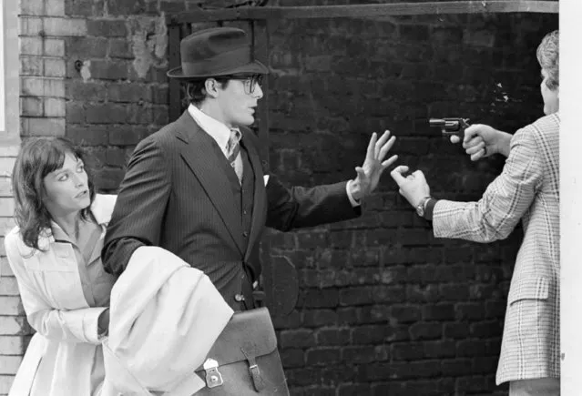 Clark Kent, aka Superman portrayed by Christopher Reeve, raises his hand as he and Lois Lane, portrayed by Margot Kidder, left, are mugged by an armed man in an alleyway in the Lower East Side during a scene from “Superman” filmed in New York City, Friday, July 8, 1977. (Photo by AP Photo)
