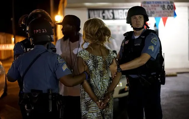 Police hold a protester who was detained in Ferguson, Missouri, August 10, 2015. (Photo by Rick Wilking/Reuters)