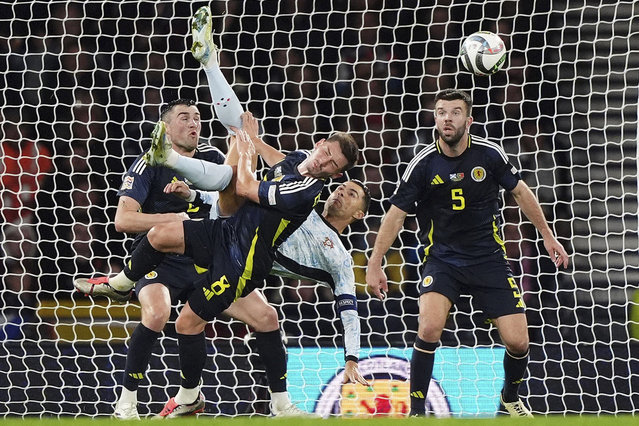 Portugal's Cristiano Ronaldo, center right, attempts an acrobatic shot on goal during the UEFA Nations League soccer match between Scotland and Portugal at Hampden Park in Glasgow, Scotland, Tuesday, October 15, 2024. (Photo by Andrew Milligan/PA Wire via AP Photo)