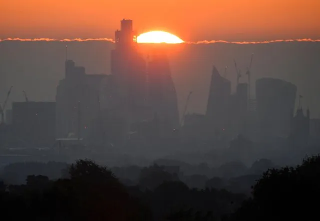 The sun rises behind skyscrapers and offices of the City of London financial district in London, Britain, May 5, 2022. (Photo by Toby Melville/Reuters)