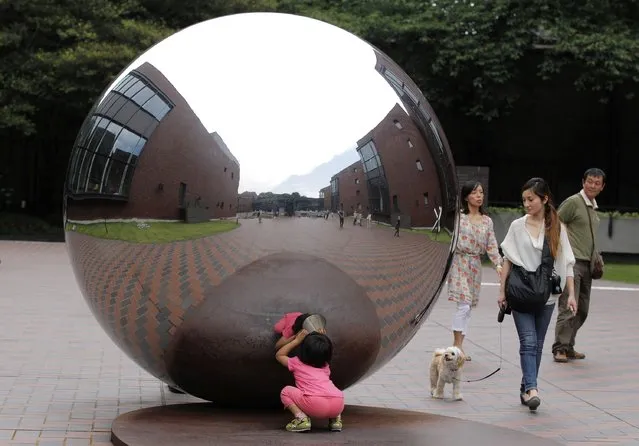 A child looks inside a hole of a sculpture at Tokyo Metropolitan Art Museum in Tokyo on June 18, 2012