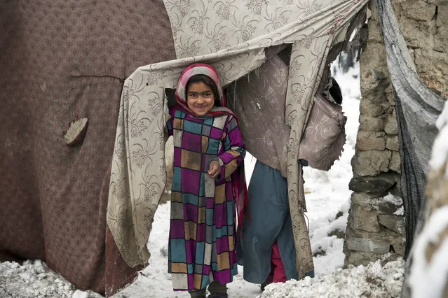 In this Sunday, January 12, 2020, file photo, a young Afghan refugee peers from her temporary home after a snowstorm at a camp on the outskirts of Kabul, Afghanistan. Afghanistan will need vast amounts of foreign funding to keep its government afloat through 2024, a U.S. agency said Thursday, even as foreign donors are increasingly angry over the cost of debilitating corruption and the U.S. seeks a peace deal with Taliban to withdraw its troops. (Photo by Rahmat Gul/AP Photo/File)