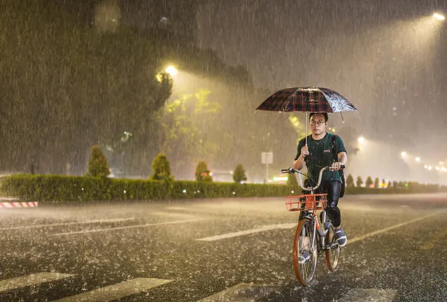 A citizen rides in the rain after typhoon Hato landed on August 22, 2017 in Shenzhen, Guangzhou Province of China. On Tuesday morning Shenzhen Meteorological Center issued a red typhoon alert for Hato. Affected by Hato, Guangdong, Fujian, Zhejiang and Taiwan will see torrential rain in the coming days. (Photo by VCG/VCG via Getty Images)