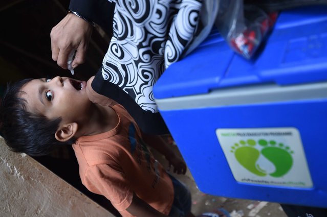 A health worker administers polio vaccines to a child during a door-to-door vaccination campaign in Karachi, Pakistan, 31 October 2024. Pakistan has commenced a nationwide anti-polio campaign from 28 October to 03 November, aiming to vaccinate 45 million children under five years old across 71 affected districts. This initiative, which includes an additional dose of vitamin A to enhance immunity, marks the country's third national campaign this year in response to 41 polio cases reported, predominantly in Balochistan and Sindh. Prime minister Shehbaz Sharif has highlighted the urgency of eradicating polio, calling it a 'collective responsibility' and emphasizing the need for unity in making Pakistan polio-free, as the disease remains endemic only in Pakistan and Afghanistan. (Photo by Shahzaib Akber/EPA/EFE)
