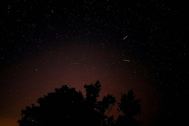 Meteors streak past stars in the night sky during the annual Perseid meteor shower above Santo Tome del Puerto, in Segovia, Spain on August 12, 2024. (Photo by Ana Beltran/Reuters)