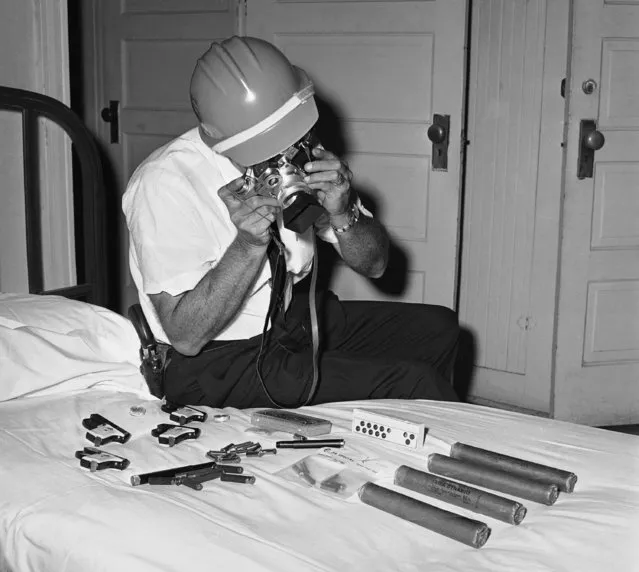 In this June 10, 1963 file photo, Lt. W.B. Painter, a state investigator, photographs a cache of pistols, dynamite, pocket tear gas guns, and other weapons confiscated in Tuscaloosa, Ala., a day before the integration of the University of Alabama. (Photo by AP Photo)