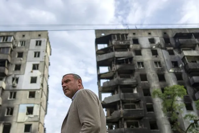 American actor Liev Schreiber stands in front of a house which have been destroyed by Russia bombardment in Borodianka, near Kyiv, Ukraine, on Monday, August 15, 2022. (Photo by Evgeniy Maloletka/AP Photo)
