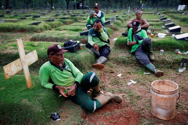 Gravediggers rest as they wait for new coffins at a cemetery complex provided by the government for coronavirus disease (COVID-19) victims in Jakarta, Indonesia on April, 22, 2020. (Photo by Willy Kurniawan/Reuters)
