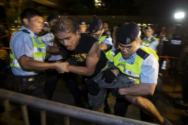 A pro-democracy activist is detained by the police during a confrontation outside the hotel where China's National People's Congress (NPC) Standing Committee Deputy General Secretary Li Fei is staying, in Hong Kong September 1, 2014. NPC Standing Committee set the stage for a political showdown on Sunday when it rejected democrats' demands for the right to freely choose Hong Kong's next leader in 2017, leading scores of protesters to take to the streets. (Photo by Tyrone Siu/Reuters)