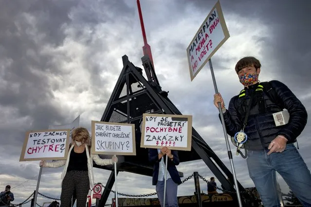 Protestors hold placards during a protest against the response of the government to the novel coronavirus COVID-19 pandemic on April 29, 2020, in Prague. (Photo by Michal Cizek/AFP Photo)