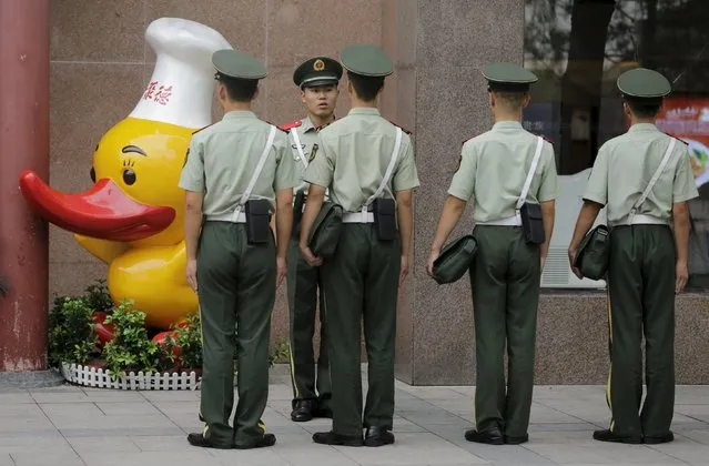 Paramilitary policemen gather outside a closed Quanjude Roast Duck restaurant next to Tiananmen Square in central Beijing August 31, 2015. Beijing is battening down the hatches and cranking up the propaganda ahead of a massive military parade this week to mark the end of World War Two, shooing cars from streets and shutting factories for the Communist Party's biggest event of the year. (Photo by Jason Lee/Reuters)