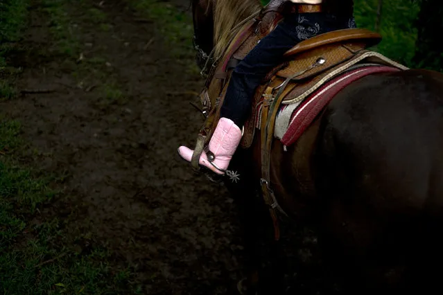 In this July 29, 2016 photo, cowgirl Dariadna Corujo rides her horse near a farm in Sancti Spiritus, central Cuba. At the tender age of 6, Dariadna is already an expert barrel racer and calf roper, wearing pink boots as she competes in rodeos on the flat grasslands of central Sancti Spiritus province. (Photo by Ramon Espinosa/AP Photo)