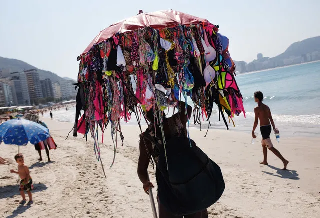 A vendor sells bikinis along Copacabana Beach ahead of the upcoming 2016 Summer Olympics in Rio de Janeiro, Brazil, Tuesday, August 2, 2016. The iconic Copacabana beach will be the starting point for the road cycling race, marathon swimming and triathlon competitions during the Olympics. (Photo by David Goldman/AP Photo)