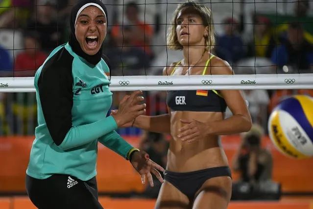 Germany's Laura Ludwig (R) watches as Egypt's Doaa Elghobashy reacts during the women's beach volleyball qualifying match between Germany and Egypt at the Beach Volley Arena in Rio de Janeiro on August 7, 2016, for the Rio 2016 Olympic Games. (Photo by Yasuyoshi Chiba/AFP Photo)