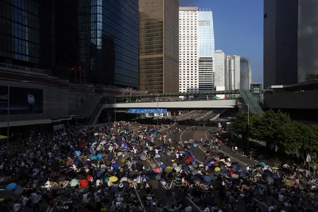 Protesters block the main road to the financial Central district (background) in Hong Kong September 29, 2014. Riot police advanced on Hong Kong democracy protesters in the early hours of Monday, firing volleys of tear gas after launching a baton-charge in the worst unrest there since China took back control of the former British colony two decades ago. (Photo by Bobby Yip/Reuters)