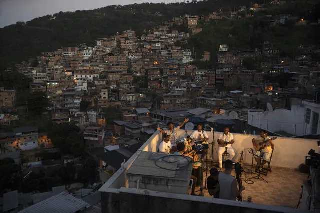 Members of the “Tempero de Criola” band perform amid the new coronavirus pandemic at the Turano favela, in Rio de Janeiro, Brazil, Friday, June 19, 2020. A group of musicians playing Samba offered a small concert to the residents of Turano favela, most of whom remain quarantined to curb the spread of COVID-19. Residents could watch the performance from their windows, balconies or via internet. (Photo by Silvia Izquierdo/AP Photo)