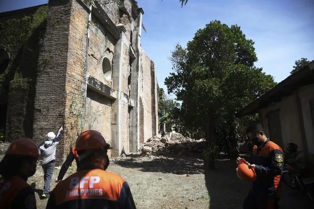 Firemen stand beside a damaged church after a strong earthquake at Ilocos Norte, Northern Philippines on Wednesday October 26, 2022. A strong earthquake rocked a large swathe of the northern Philippines, injuring multiple people and forcing the closure of an international airport and the evacuation of patients in a hospital, officials said Wednesday. (Photo by AP Photo/Stringer)