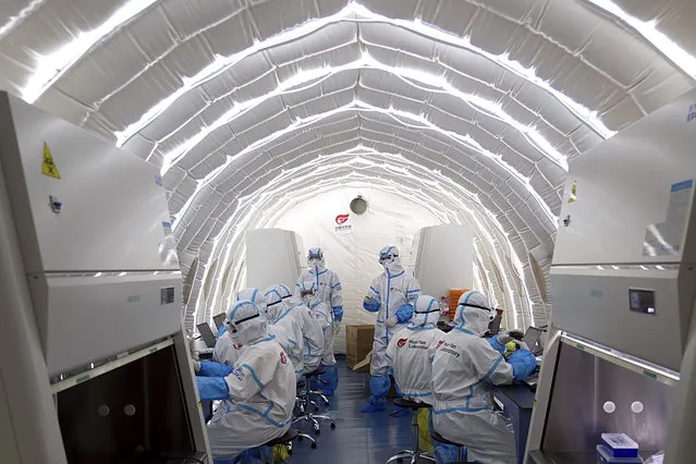 In this photo released by Xinhua News Agency and taken on June 23, 2020, staff members work in an inflatable COVID-19 testing lab in Beijing. The lab provided by Chinese biotech company BGI Genomics is capable of running 30,000 nucleic acid test daily. China appears to have tamed a new outbreak of the virus in Beijing, once again demonstrating its ability to quickly mobilize vast resources by testing nearly 2.5 million people in 11 days. (Photo by Chen Zhonghao/Xinhua via AP Photo)