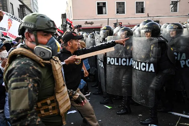 Supporters of Peru's President Pedro Castillo clash with riot police during a demonstration in Lima on November 10, 2022. Hundreds of supporters of Peruvian President Pedro Castillo marched through the streets of Lima on Thursday in support of the leftist president, who is under six investigations for alleged corruption. (Photo by Ernesto Benavides/AFP Photo)