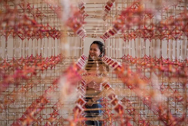 A woman looks through an art installation of Rattana Sudjarit at the Bangkok Art and Cultural Center in Bangkok, Thailand, Tuesday, June 23, 2020. (Photo by Gemunu Amarasinghe/AP Photo)