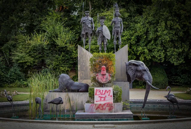 A picture taken on August 3, 2020 shows a bust of former king Leopold II covered in red paint, with "BLM" spray-painted on its base, in the park of the Africa Museum in Tervuren, near Brussels. The bust of former Belgian king Leopold II, a controversial figure from Belgium's colonial past, has again been damaged in the grounds of the Africa Museum. The statue, which had already been painted in June, is regularly defaced. (Photo by François Walschaerts/AFP Photo)