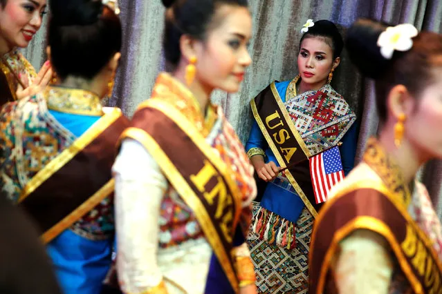 A woman in a USA sash, who would help show U.S. President Barack Obama to his seat, waits with other women in traditional dress for the start of the ASEAN Summit gala dinner in Vientiane, Laos September 7, 2016. (Photo by Jonathan Ernst/Reuters)