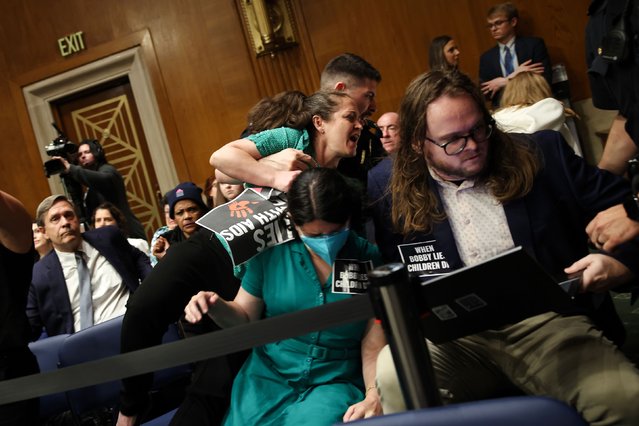 US Capitol Police detain protesters who disrupted a Senate committee hearing while Health and Human Services Secretary Robert F. Kennedy Jr., not pictured, was delivering prepared remarks on Wednesday, May 14, 2025. Lawmakers repeatedly pressed Kennedy on canceled medical research and mass layoffs during the hearings. (Photo by Samuel Corum/Getty Images)