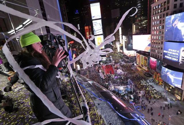 People throw streamers from the Marriott Marquis during New Year's celebrations in Times Square, New York, Sunday, December 31, 2017. (Photo by Seth Wenig/AP Photo)