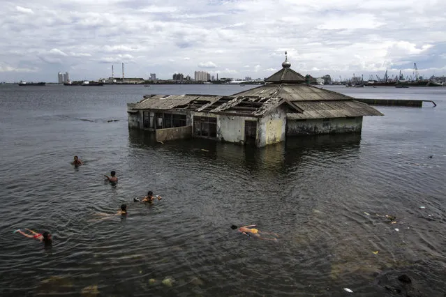 Children swim beside a mosque that submerged in sea water at Muara Baru area in Jakarta, Indonesia, on January 4, 2018. The flash floods that swamped Muara Baru area is caused by supermoon phenomenon which its peak will occur on January 31, 2018. (Photo by Eko Siswono Toyudho/Anadolu Agency/Getty Images)