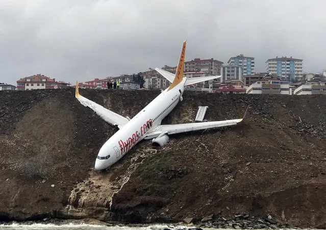 A Pegasus airplane is seen stuck in mud as it skidded off the runway after landing in Trabzon Airport, Turkey early Sunday on January 14, 2018. A passage plane which belongs to Turkey' s Pegasus Airlines skidded off the runway of Trabzon airport Saturday and ended up halfway down a steep slope into the Black Sea, Turkish media reported on Sunday. 162 passengers and crew on board were safely evacuated. (Photo by Hakan Burak Altunoz/Anadolu Agency/Getty Images)