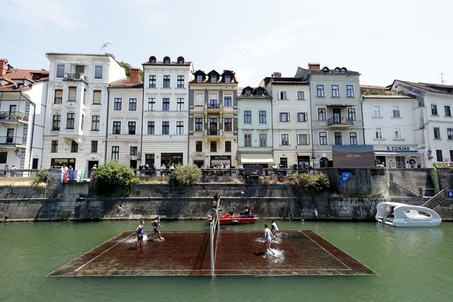 Teams compete on a partially-submerged volleyball court in the Slovenian capital Ljubljana on July 4, 2025. (Photo by Borut Zivulovic/Reuters)