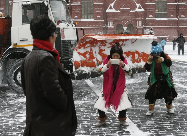 Tourists taking pictures in Red Square during a snowfall in Moscow, Russia on February 4, 2018. (Photo by Alexander Shcherbak/TASS)