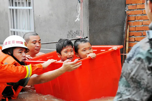Rescuers evacuate young flood-affected residents through floodwaters brought by typhoon Megi in Ningde, eastern China's Fujian province on September 28, 2016. 
Typhoon Megi smashed into the Chinese mainland on September 28 morning, killing one person, after leaving a trail of destruction and four people dead in Taiwan. (Photo by AFP Photo/Stringer)