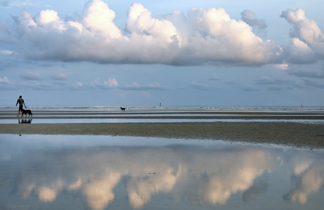 A person walks with dogs on Bay St. Louis Beach, a city hard-hit by Hurricane Katrina, on August 04, 2025 in Bay St. Louis, Mississippi. Hurricane Katrina devastated the historic town destroying or severely damaging nearly all of its 4,500 homes, but its rebuilding has been a success story. Bay St. Louis is now one of the fastest growing cities in Mississippi. New Orleans and the Gulf Coast region are preparing to mark the 20 year anniversary of Hurricane Katrina, which occurred on August 29, 2005. Katrina resulted in nearly 1,400 deaths, according to revised statistics from the National Hurricane Center, and remains the costliest storm in U.S. history at around $200 billion in today’s dollars. (Photo by Mario Tama/Getty Images)