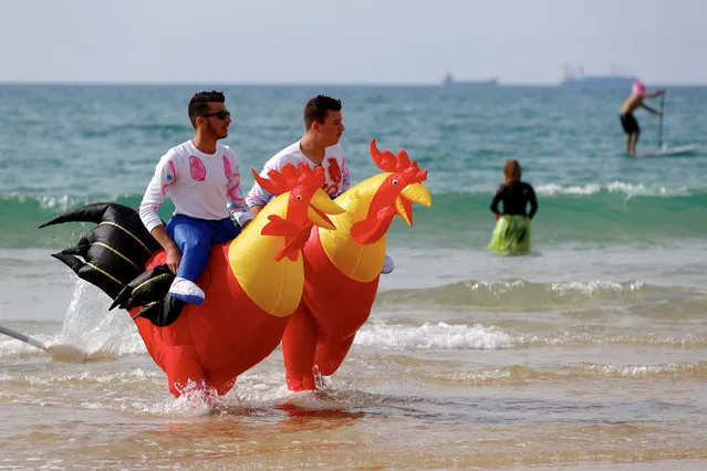 People dressed in costumes take part in a local surfing competition to celebrate the Jewish holiday of Purim, in the southern city of Ashdod, Israel on March 2, 2018. (Photo by Amir Cohen/Reuters)