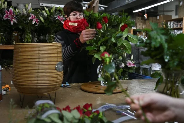 Victoria Darst, a floral designer, assembles a flower arrangement for a customer on the eve of Valentine's Day at Nanz & Kraft Florists in Louisville, Kentucky, U.S., February 13, 2023. (Photo by Jon Cherry/Reuters)