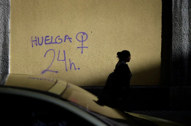 A woman walks past graffiti reading “Strike. 24 hours” alongside a female gender symbol in Bilbao, Spain on March 6, 2018, in reference to a women only strike called for Thursday's International Women's Day. (Photo by Vincent West/Reuters)