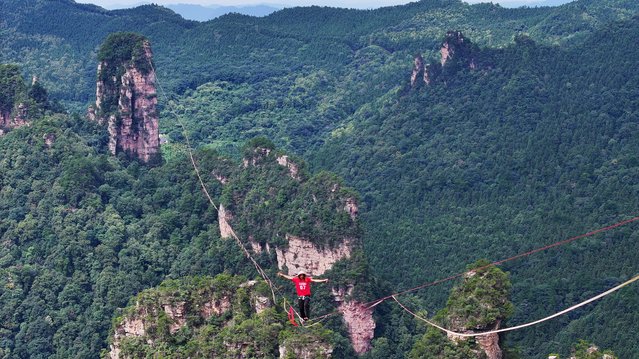 Slackline athlete competes during the “Slackline King” Championship final match at Huangshizhai scenic spot on August 20, 2025 in Zhangjiajie, Hunan Province of China. 20 elite slackline athletes from 10 countries and regions competed at an altitude of more than 1,000 meters, before Williams emerged as the winner, with Poland's Jakub Morawski and China's He Jinyi finishing second and third respectively. (Photo by Deng Daoli/VCG via Getty Images)