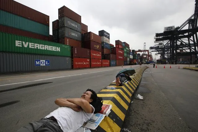 Container workers occupy and block a road during a protest at Kwai Chung Container Terminal in Hong Kong, Friday, March 29, 2013. About two hundreds container workers went on strike, demanding pay raise. The terminal is a subsidiary of Hong Kong billionaire Li Ka-shing’s company, Hutchison Whampoa. (Photo by/AP Photo)
