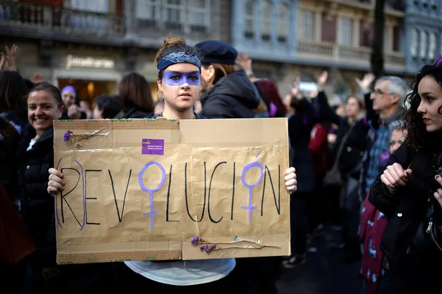 A protester holds a poster reading “Revolution” during a demonstration for women's rights on International Women's Day, in Bilbao, Spain on March 8, 2018. (Photo by Vincent West/Reuters)